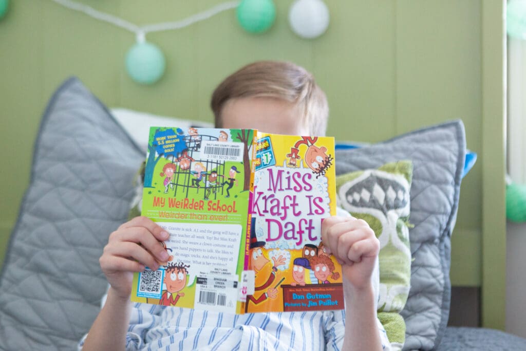 why bedtime routines are important for kids in South Jordan Utah – little boy reading a chapter book before bed